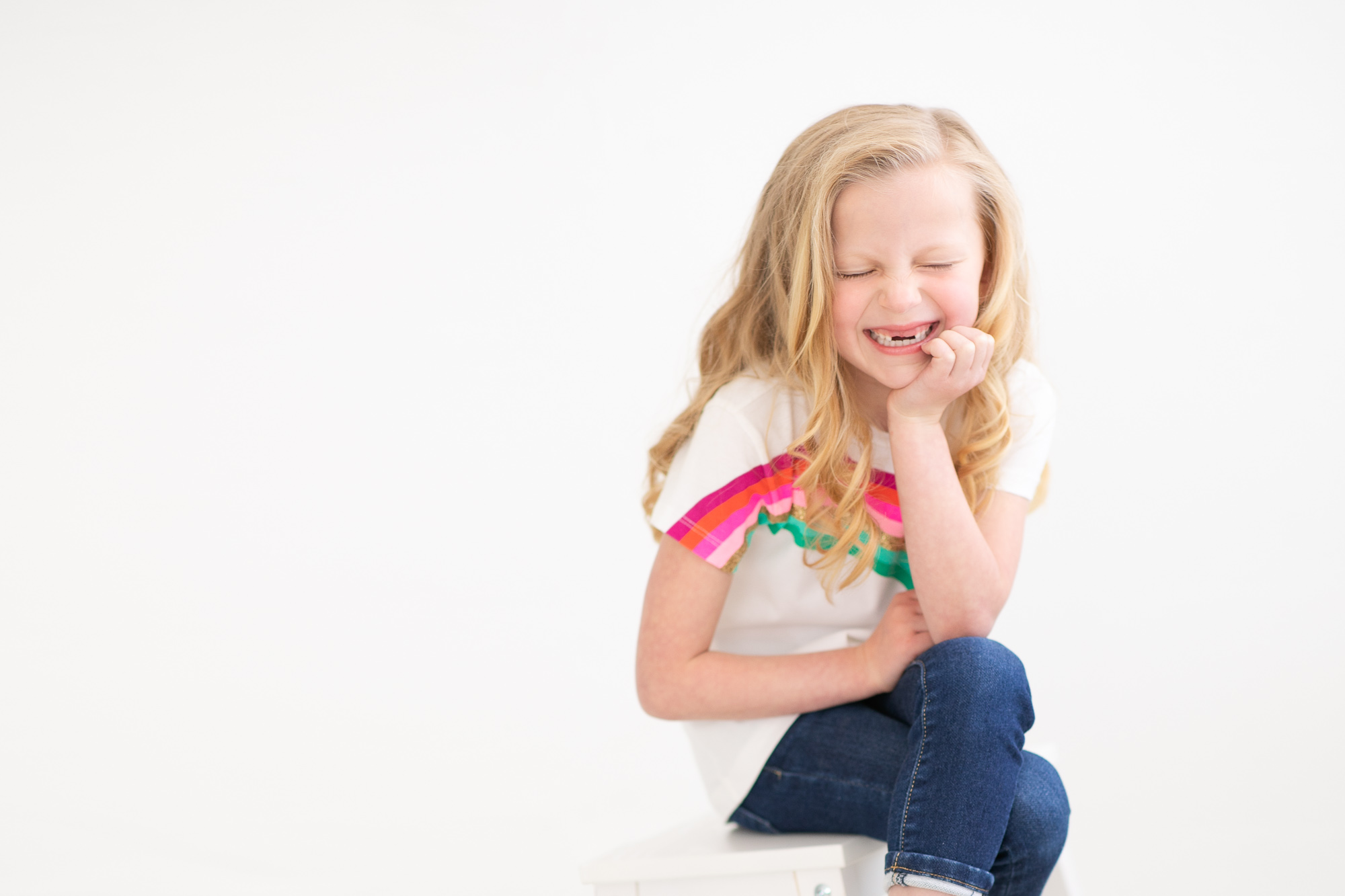 Little girl missing her. two front teeth laughing during a child photography session in Boise with Tiffany Hix Photography