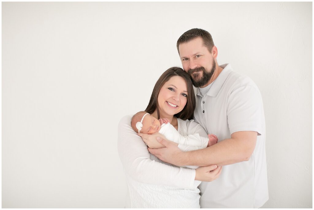 mom and dad holding newborn baby during newborn photos