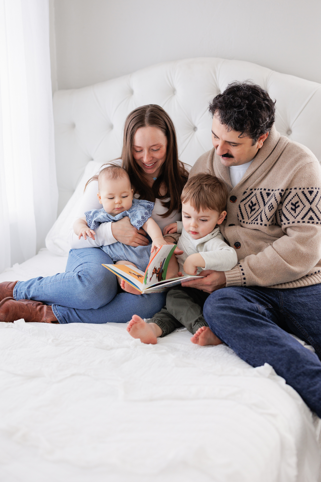 The E Family reading a book during a relaxed and cozy photography session in Tiffany's Boise studio.