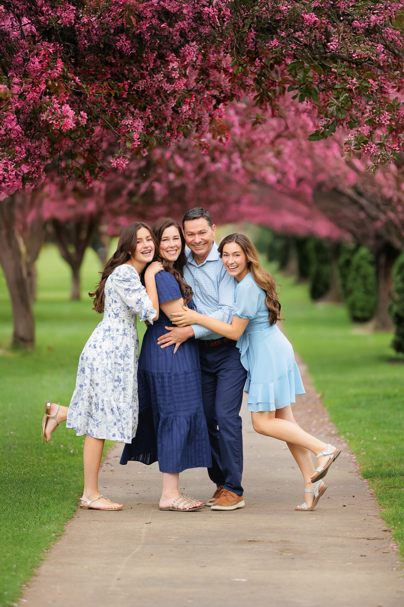 Family of 4 together on a tree lined path in Ann Morrison Park in Boise.