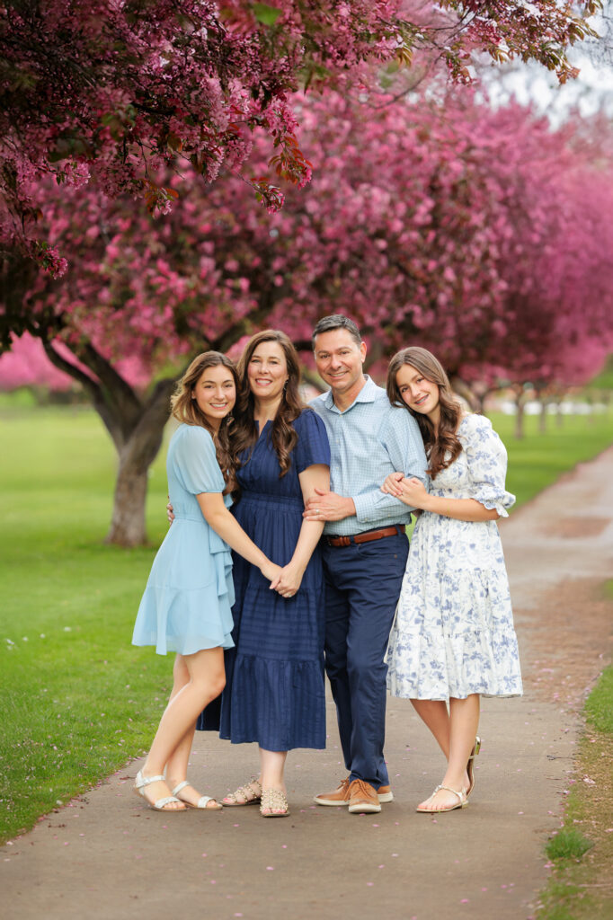 Family of 4 standing on tree lined path at Ann Morrison Park in Boise.