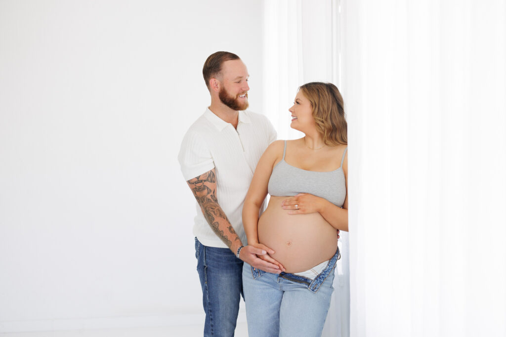First grand baby maternity portraits in Boise studio with couple embracing