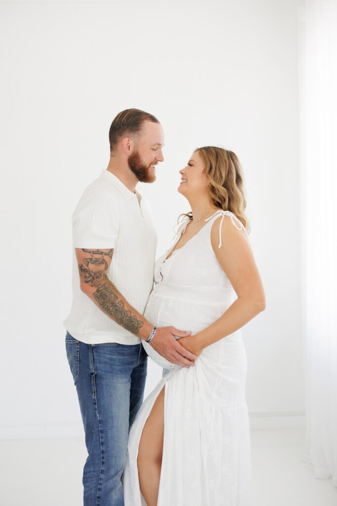 Studio maternity photos in Boise with expecting couple holding baby bump