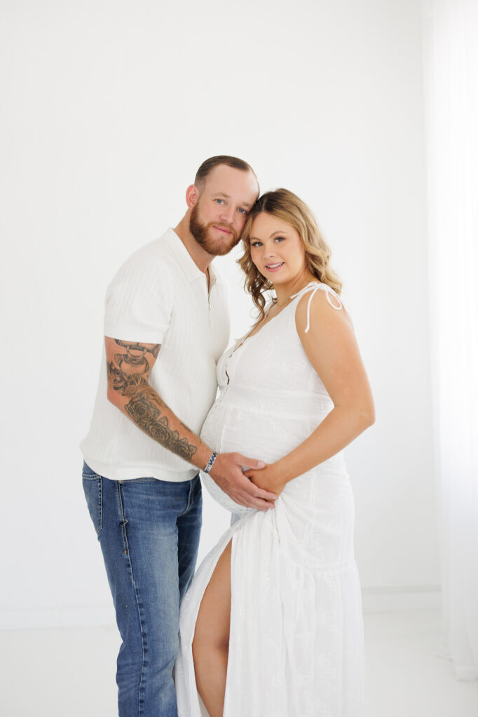 Studio maternity photos in Boise with expecting couple holding baby bump