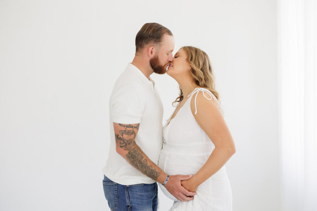 Studio maternity photos in Boise with expecting couple holding baby bump