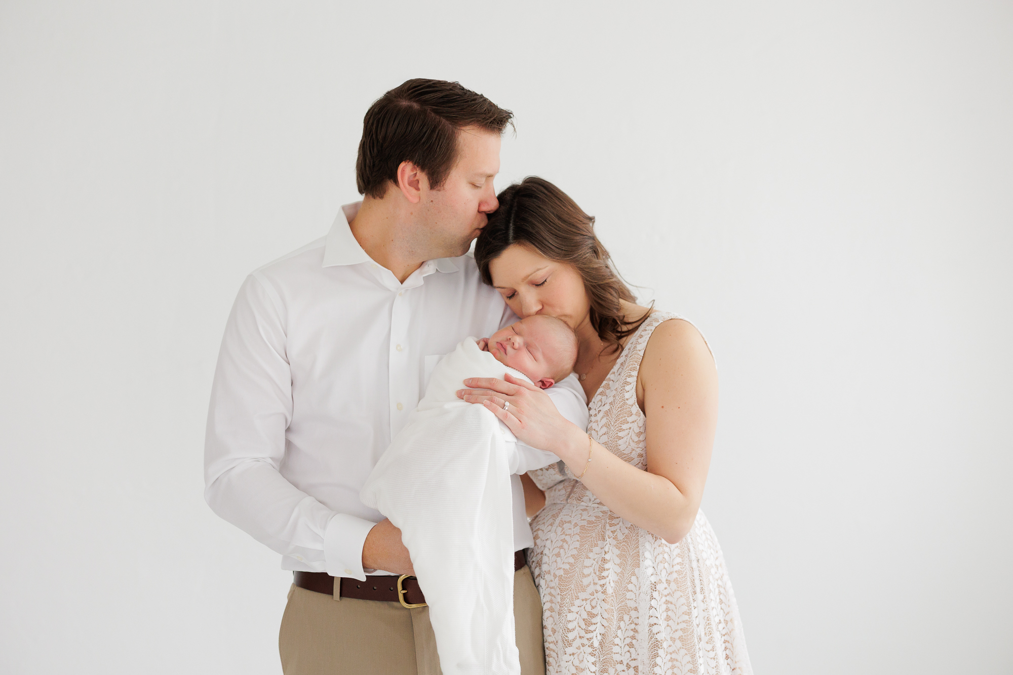 A mom and dad holding their newborn baby during newborn photos in Boise.