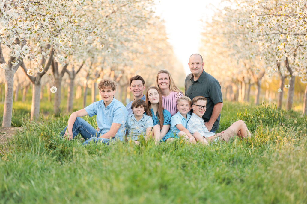 A family of 8 in an orchard during spring family photos in Boise.
